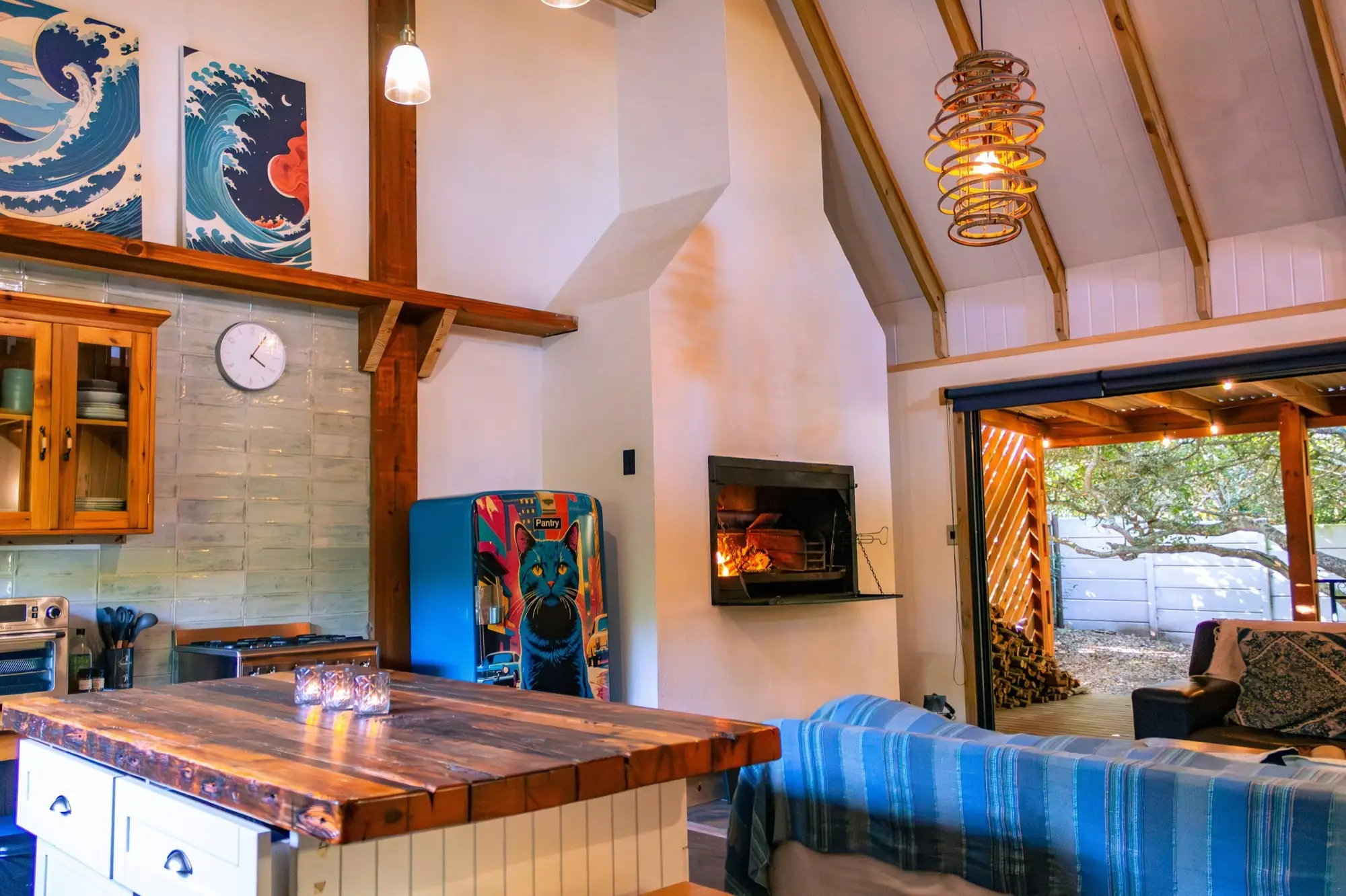 Kitchen and fireplace with the sliding doors open onto the deck and firewood stack