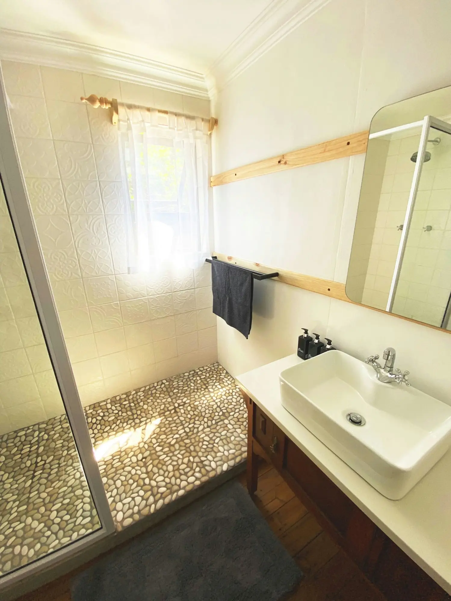 Bathroom with a pebble-floor walk-in shower and a stone basin