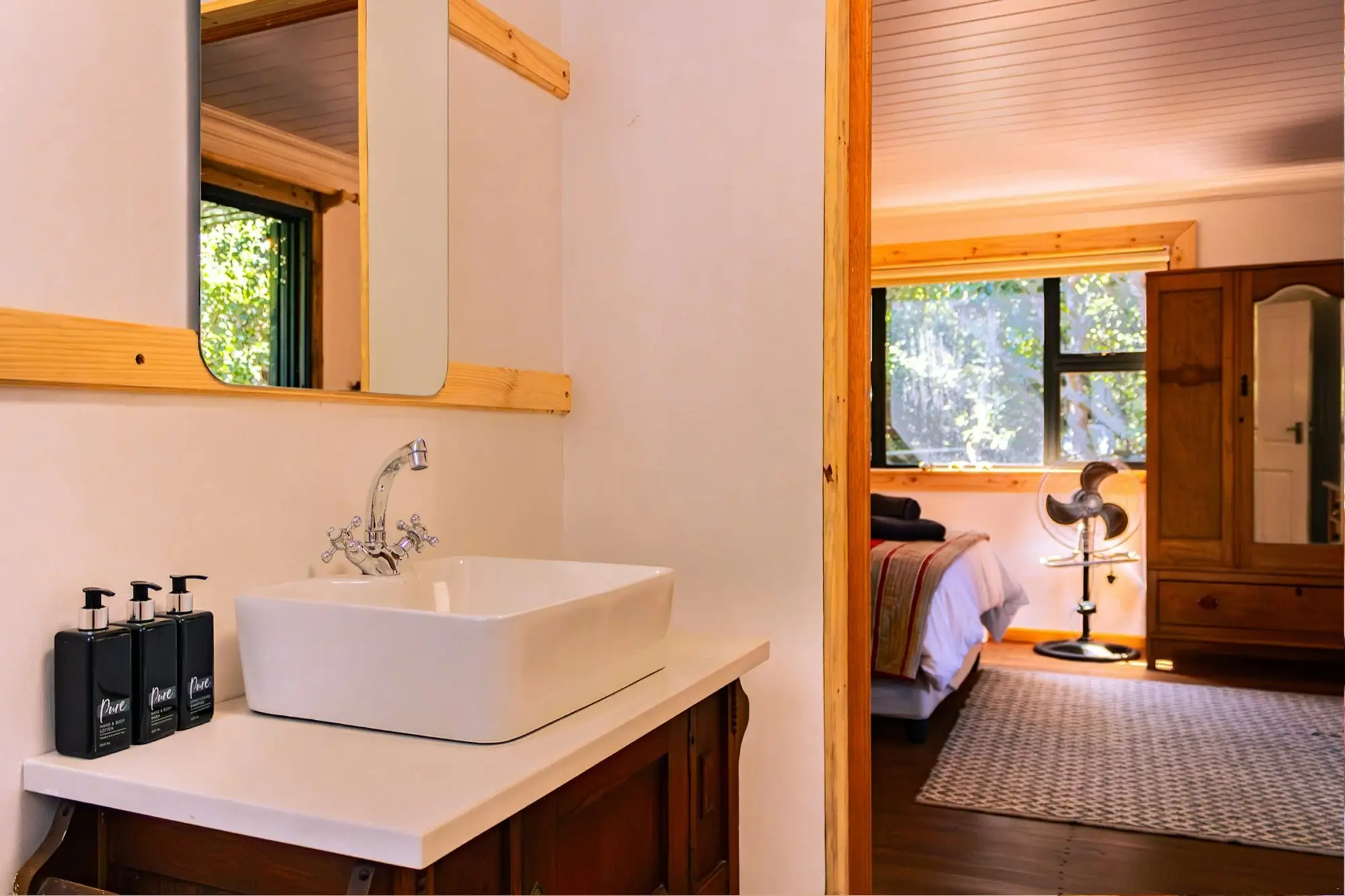 En-suite basin with a mirror, looking through to the master bedroom