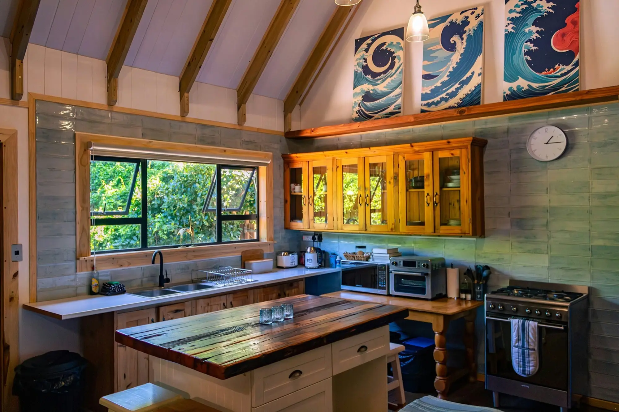 Kitchen with a wave triptych above the cabinets and a butcher-block island