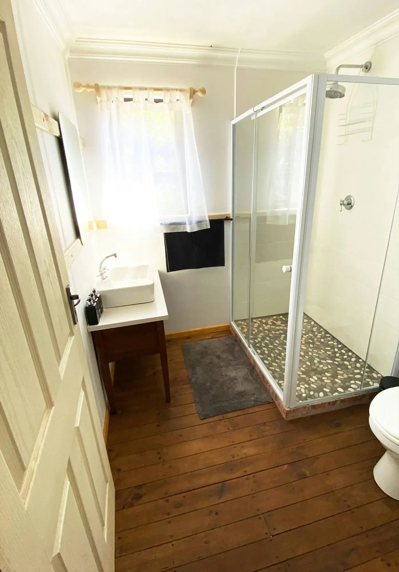 Second bathroom with a glass shower and wooden floors